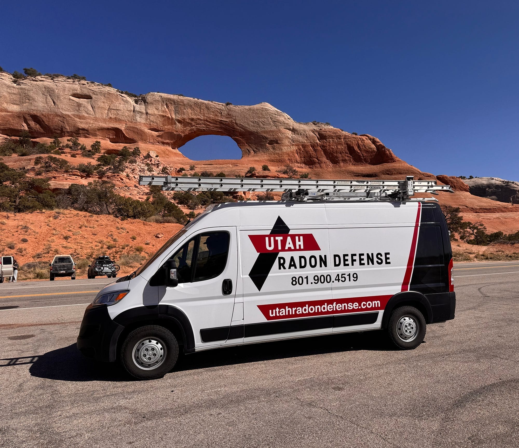 Utah Radon Defense van parked at a scenic arch offering radon mitigation services

