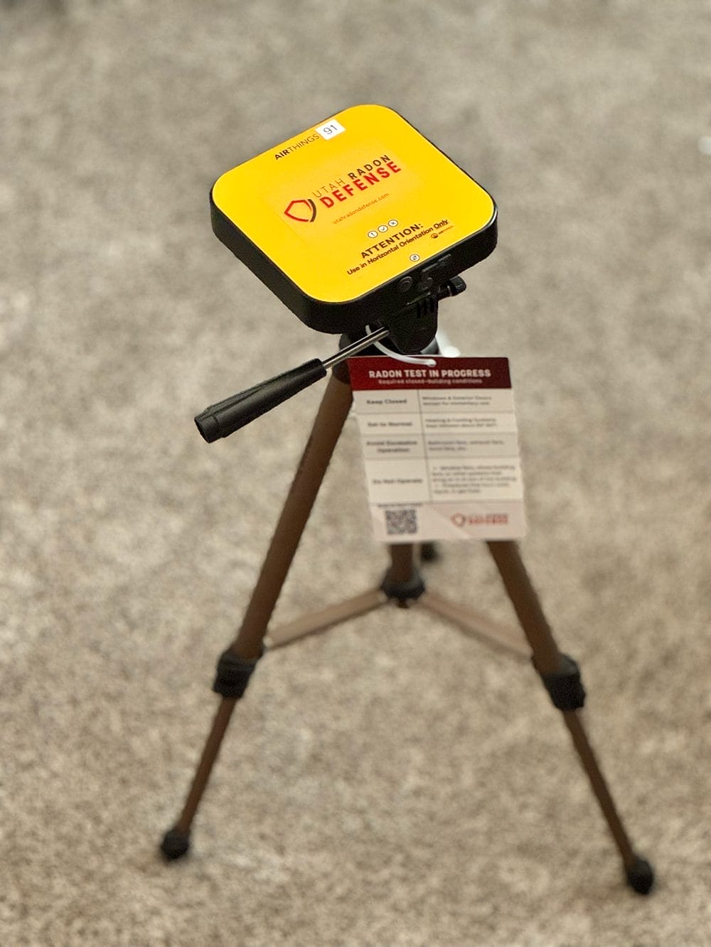 Radon detection device by Utah Radon Defense on a tripod
